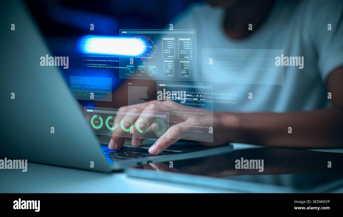 Male programmer coding on laptop with virtual screen HUD icons. Software engineer developing AI brain technology and big data analytics in dark office Stock Photo