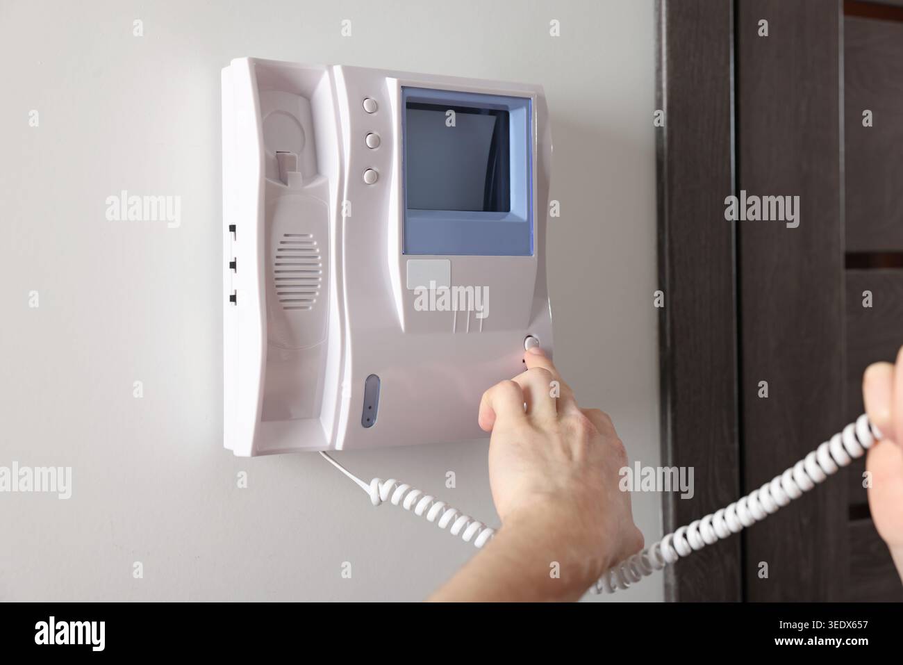 Man pressing button on intercom panel indoors, closeup Stock Photo