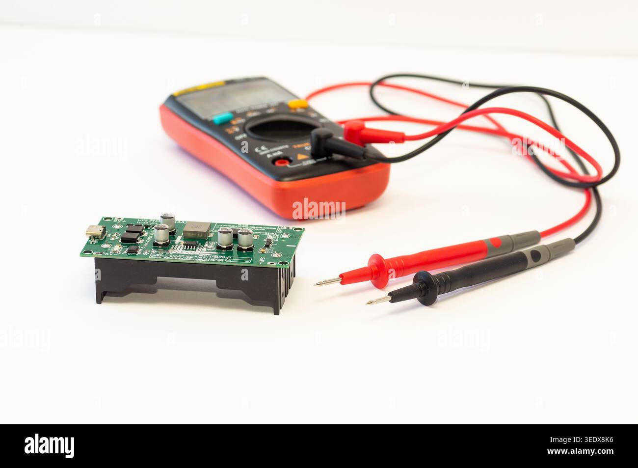 Multimeter with test probes and a circuit board Stock Photo