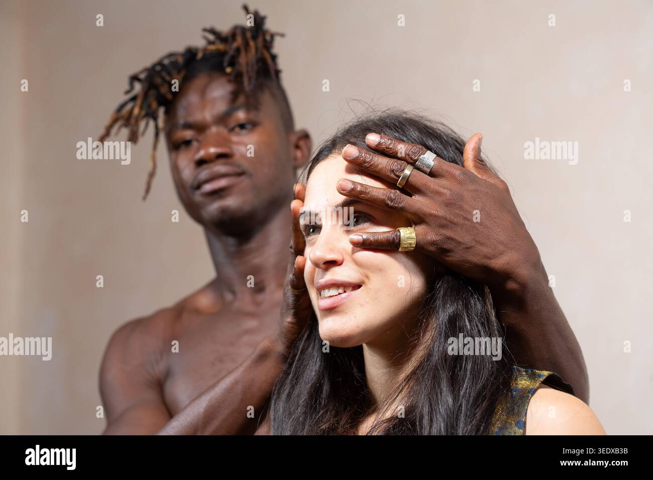 Man covering woman's eyes, illustrating connection, diversity, and trust in a relationship Stock Photo