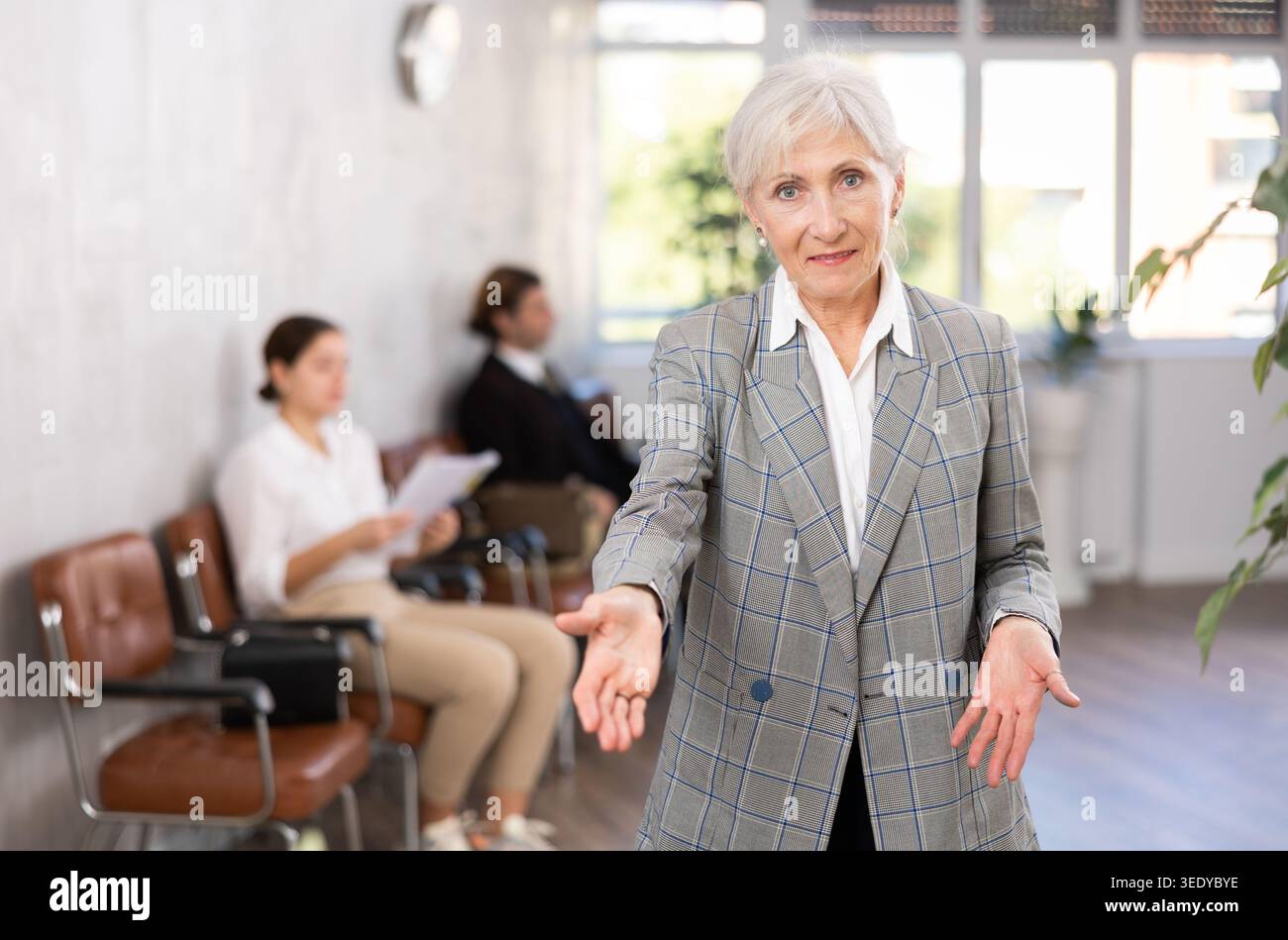 Seniore positive woman extending her hand for handshake in office Stock Photo