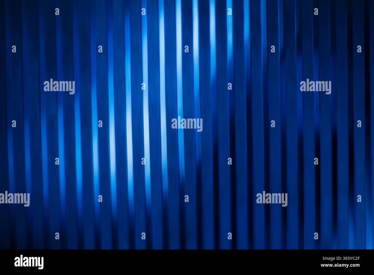 Abstract blue corrugated glass texture with vertical lines and bright light reflections Stock Photo