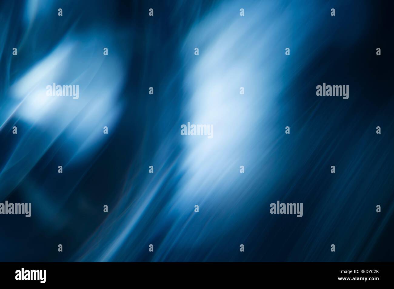 Abstract blurred blue light rays reflecting diagonally on a dark background Stock Photo