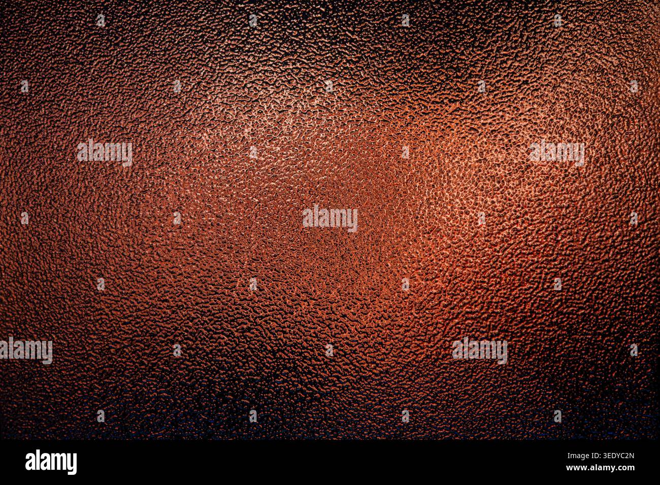 Copper colored frosted glass texture with a rough bumpy surface and warm gradient light Stock Photo
