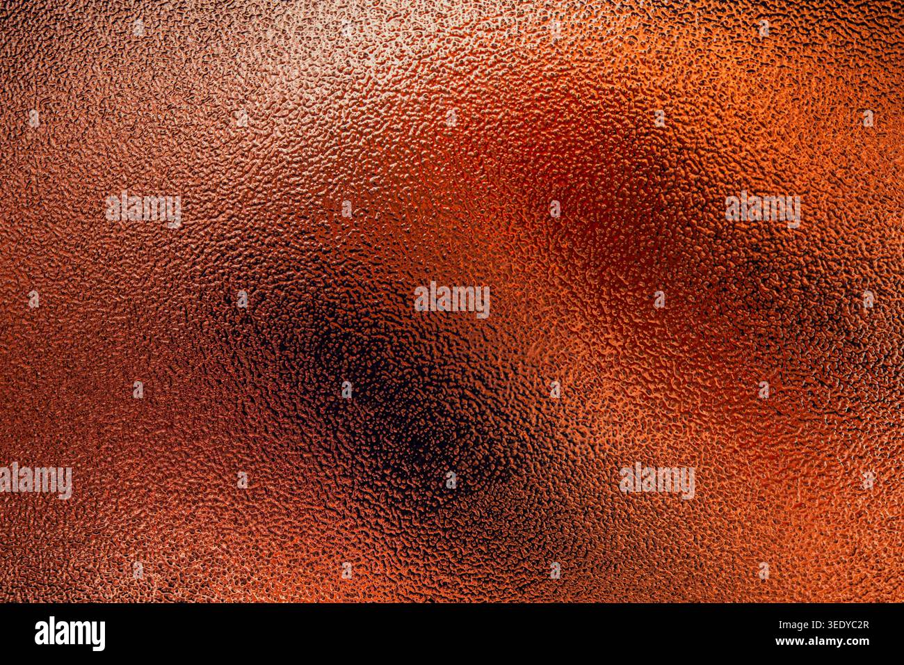 Bright copper colored frosted glass background with uneven textured surface and central illumination Stock Photo