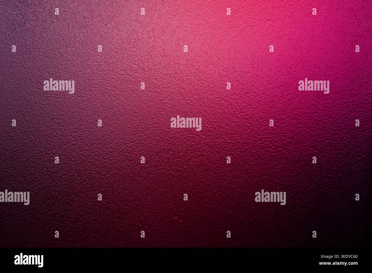Magenta and pink gradient light on a dark bumpy textured surface Stock Photo