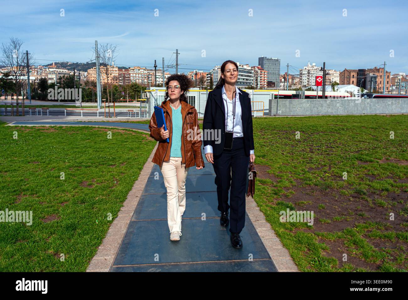 Two businesswomen walking on urban path discussing work Stock Photo