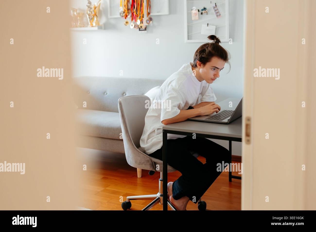 Focused young person working on laptop at home Stock Photo