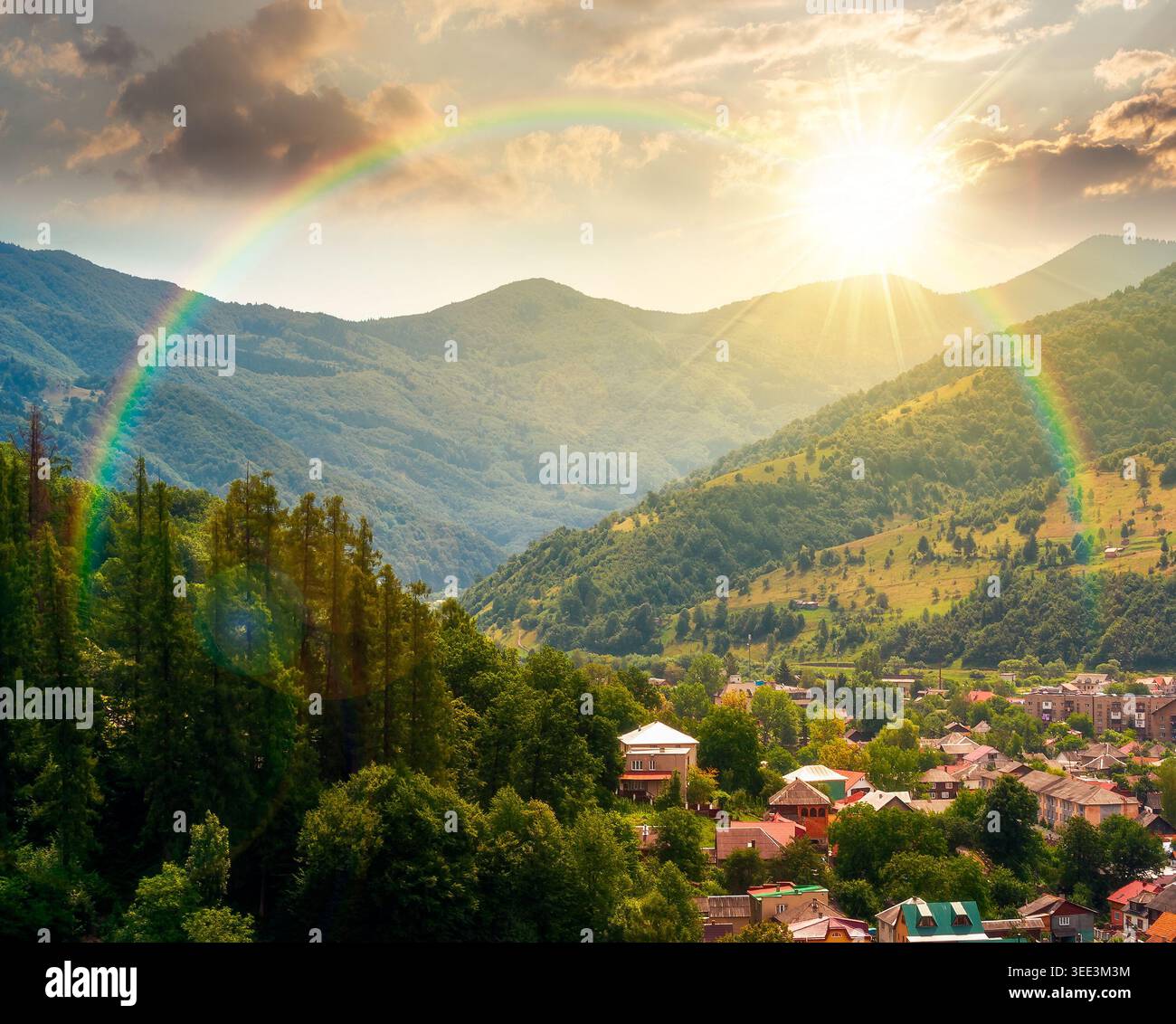sunset over carpathian mountain landscape in summer. view in to the valley of rakhiv town near forested hill of mountain range. travel background of a Stock Photo