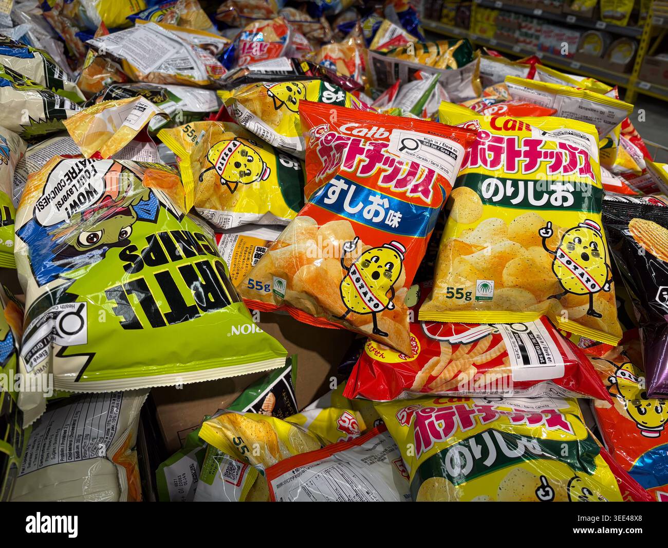 A high-angle close-up of various Calbee brand Japanese potato chip bags ...