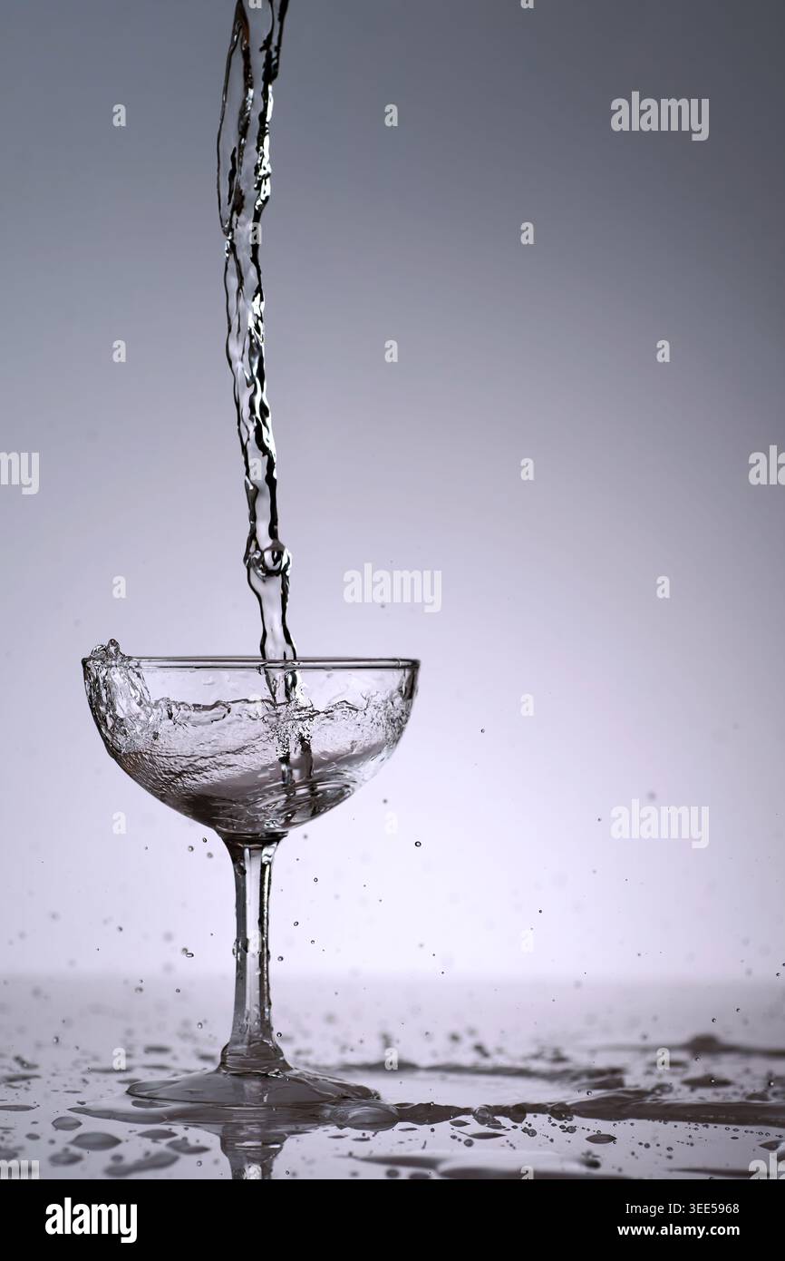 puring refreshment freshness drinking water on clean transperence glass in studio back light Stock Photo