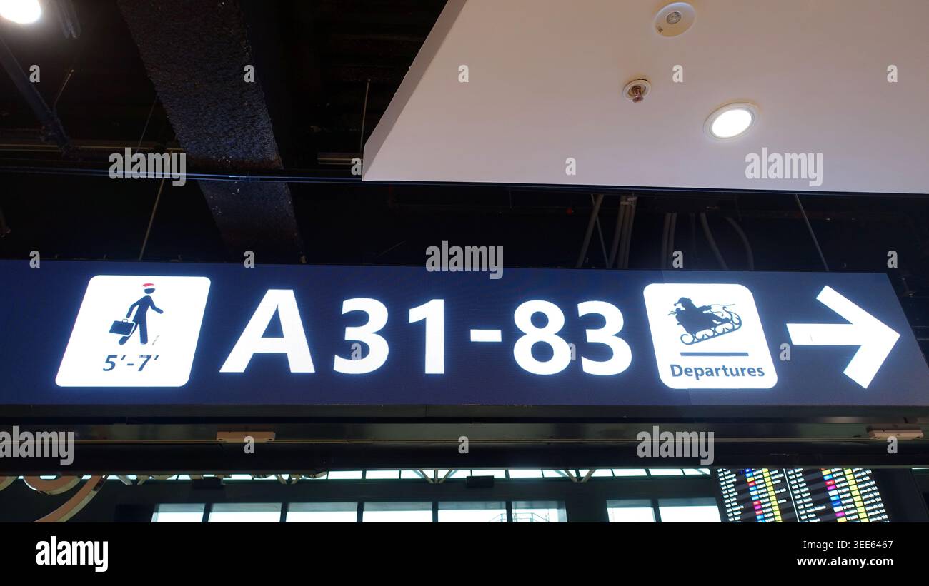 Bright illuminated airport departures sign for gates A31-83 with ...