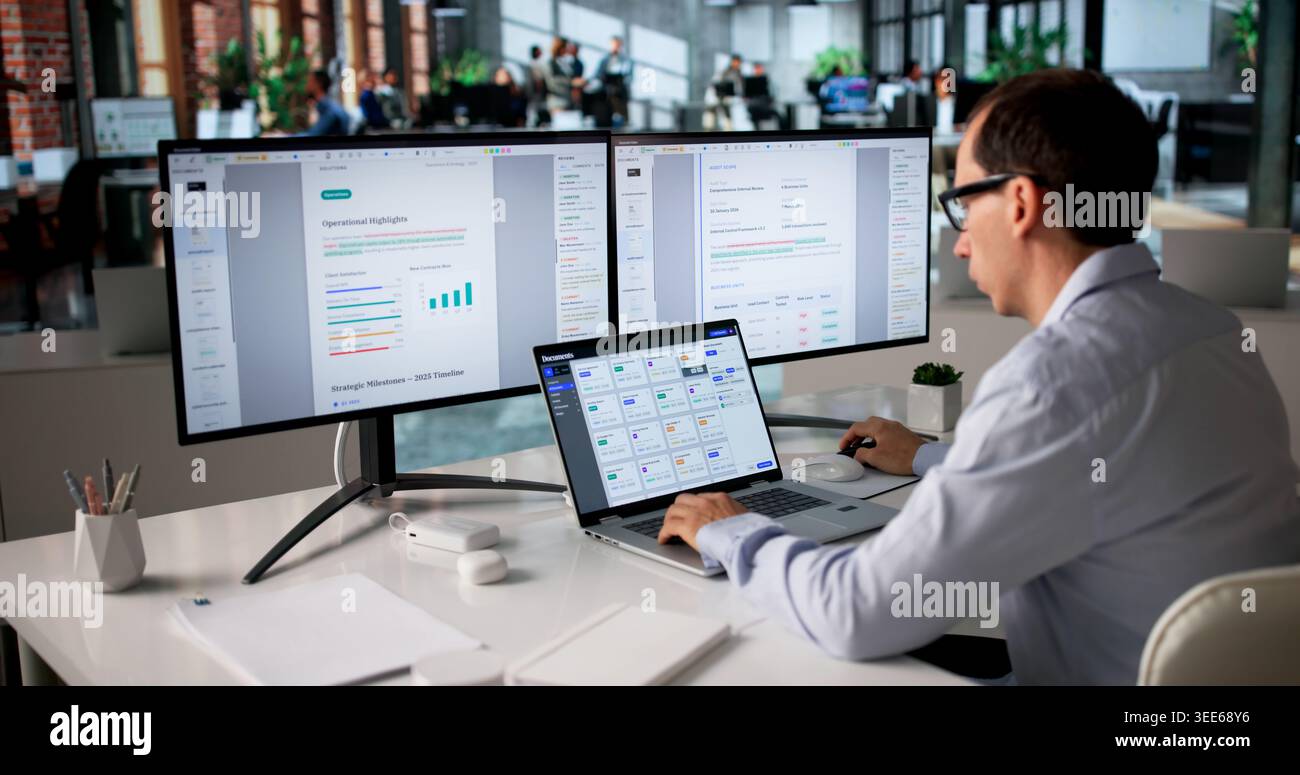 Office Manager Organizes Files On Computer Using Secure Document Management System. Stock Photo