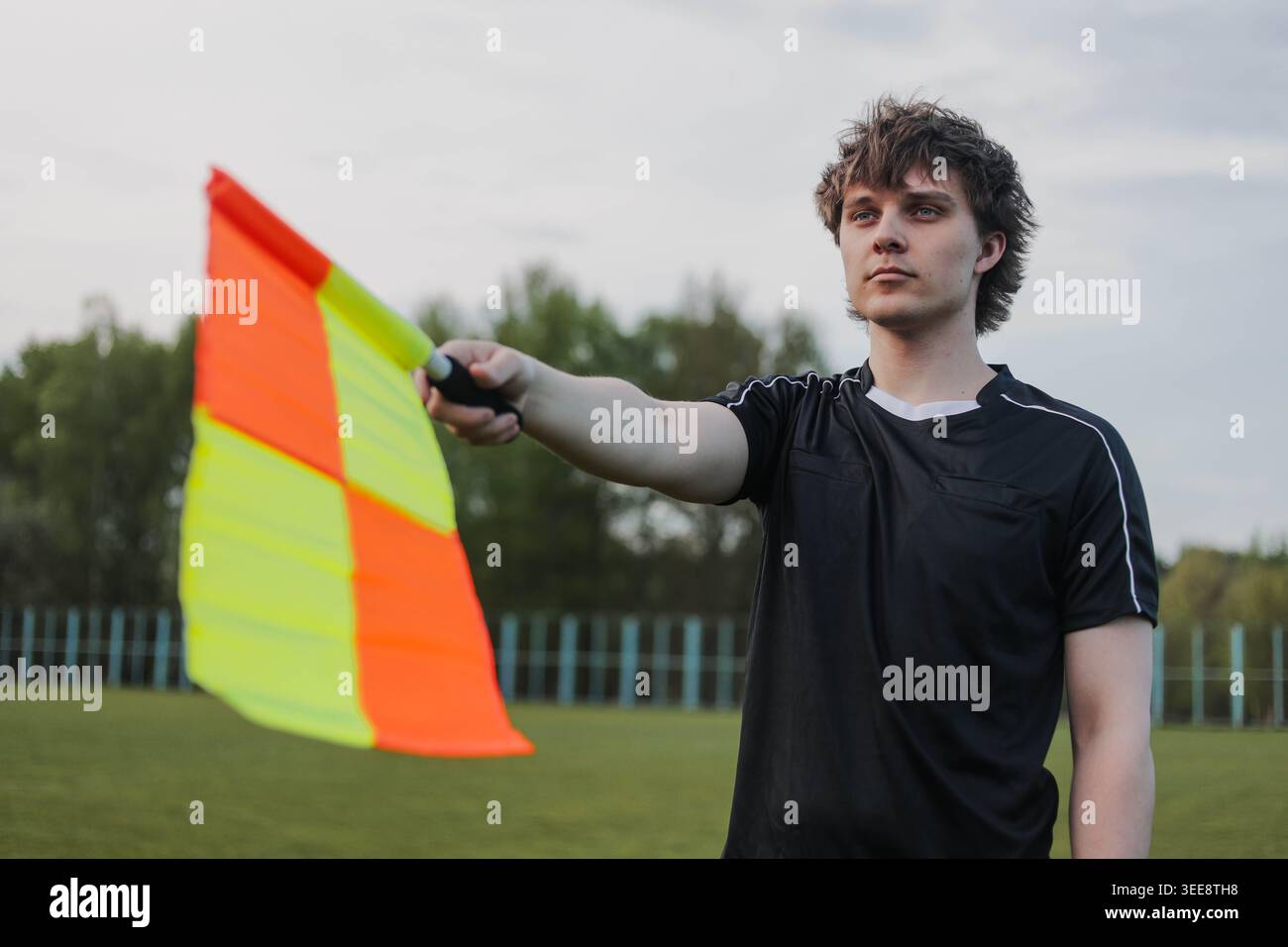 Soccer referee signaling offside with a flag during football match ...