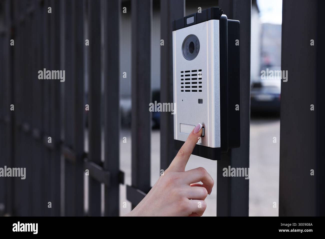 Woman pressing button on intercom panel outdoors, closeup Stock Photo