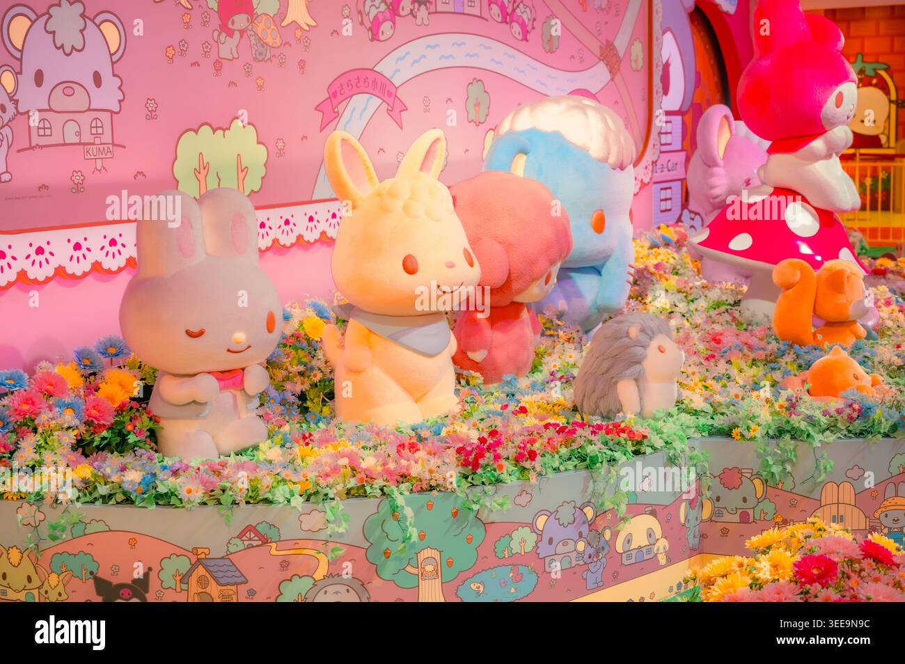 Cute Sanrio character figures arranged among flowers in a colourful themed display inside Sanrio Puroland in Tokyo. Stock Photo