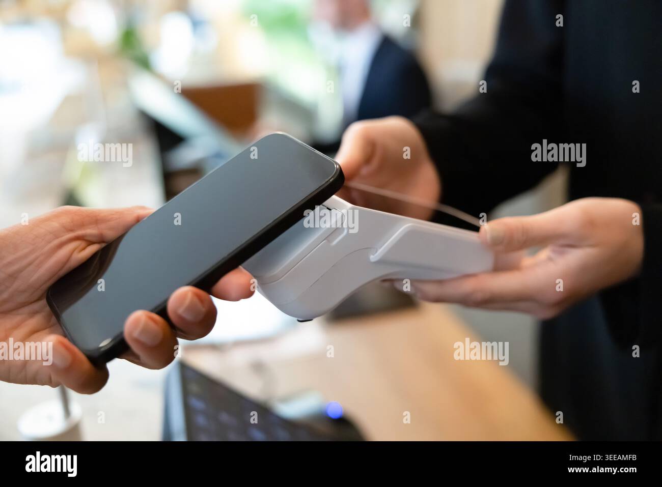 Customer making contactless payment with smartphone, closeup Stock Photo