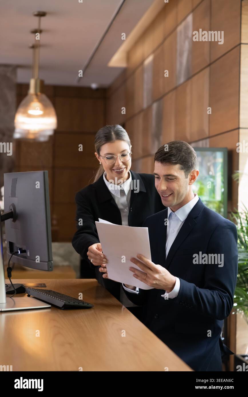Receptionists working together on daily reports and documents in reception Stock Photo