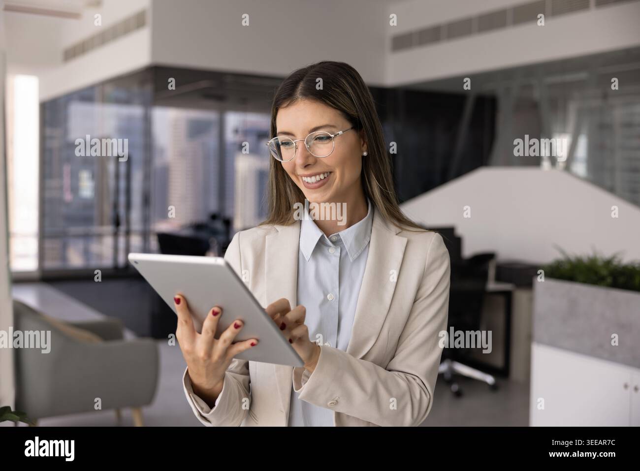 Smiling professional woman working on tablet device Stock Photo