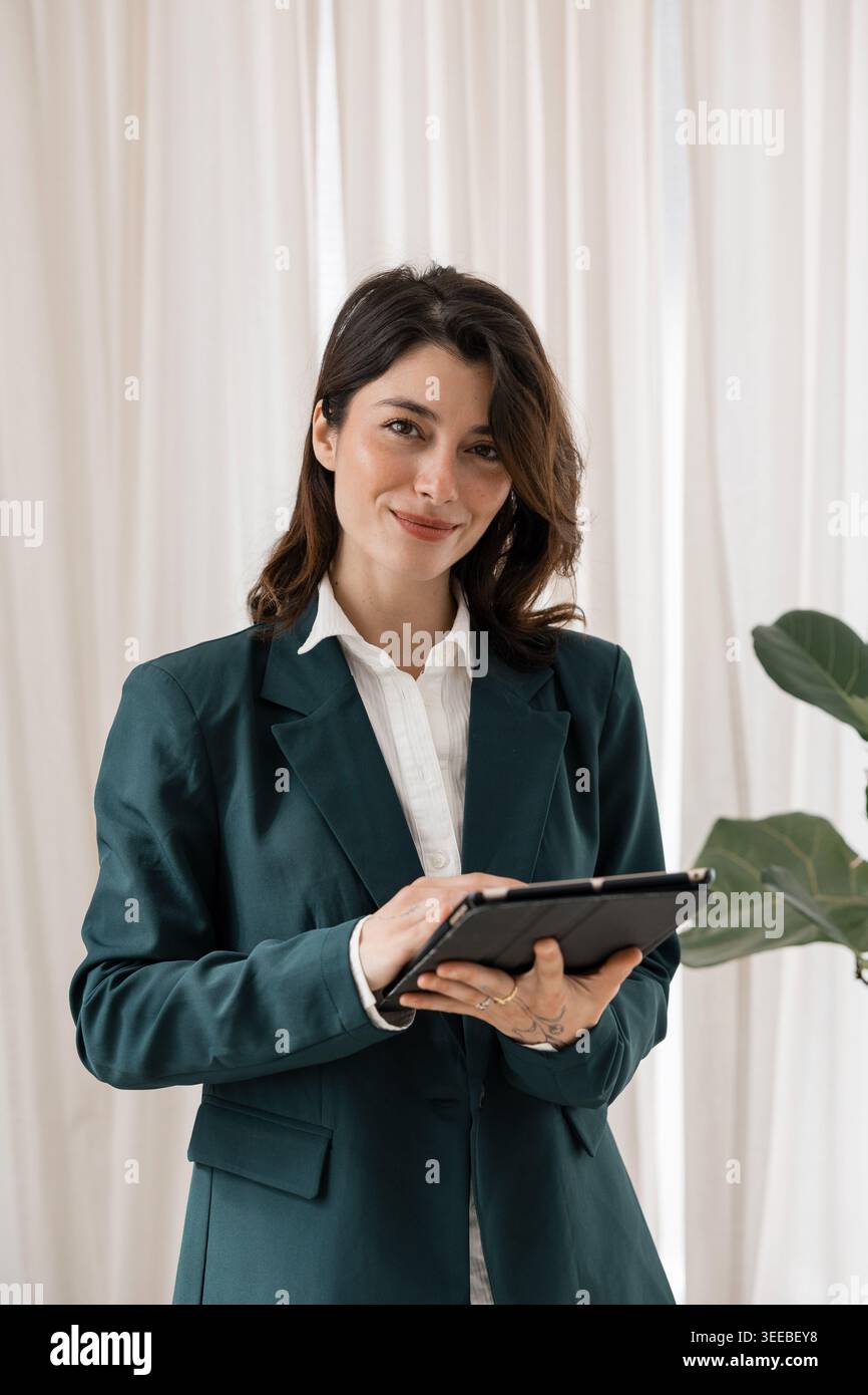 Businesswoman smiling while using digital tablet technology Stock Photo