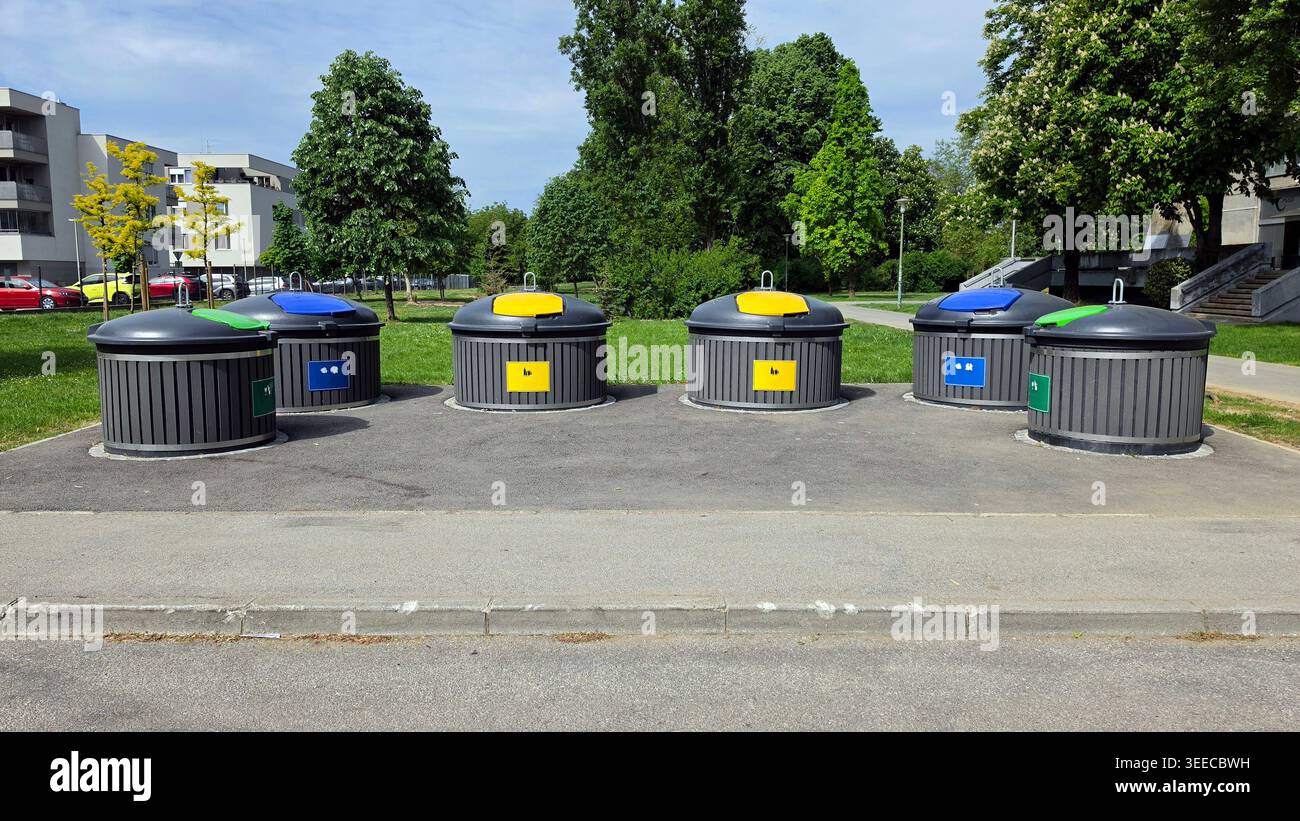 Six semi-underground circular recycling bins with grey slatted sides ...