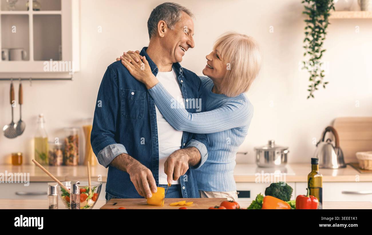Couple Cooks Together in a Kitchen While Preparing Fresh Ingredients Stock Photo