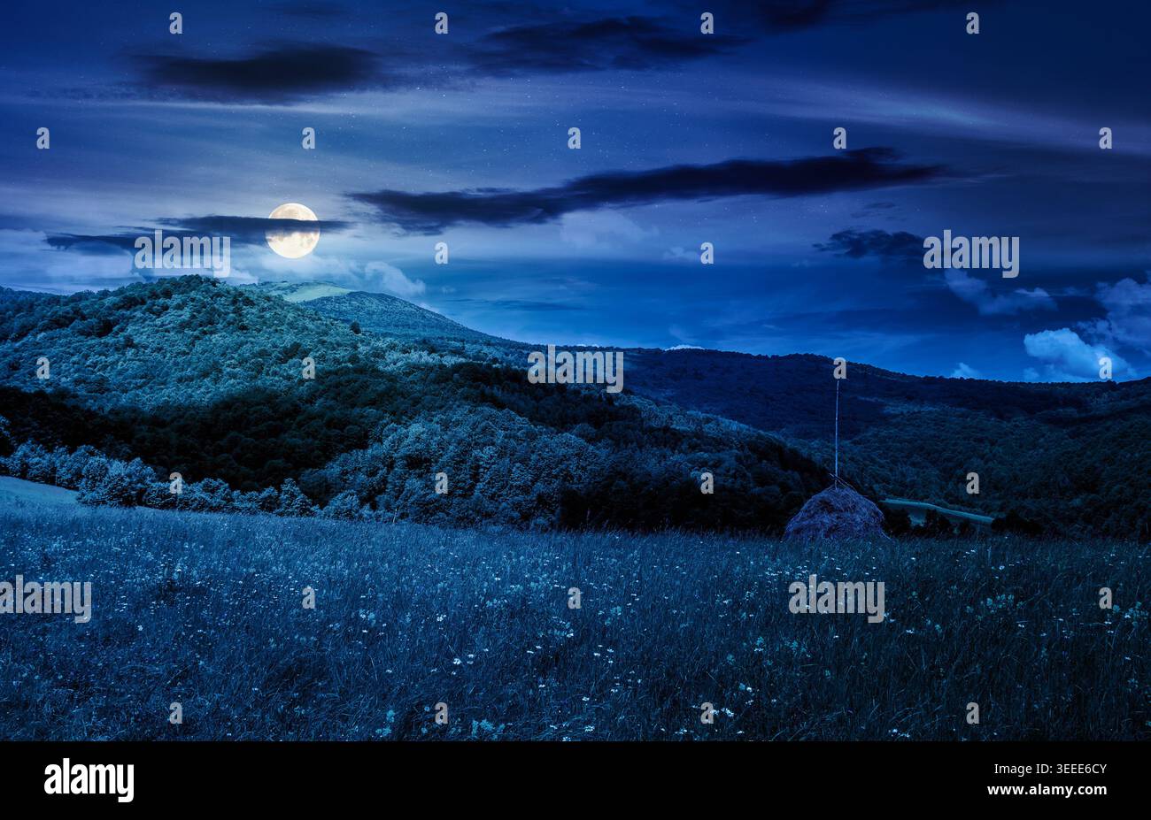 rural fields near pikui mountain in summertime at night. full moon over beautiful view of agricultural area. gorgeous mountain ridge with haystack on Stock Photo