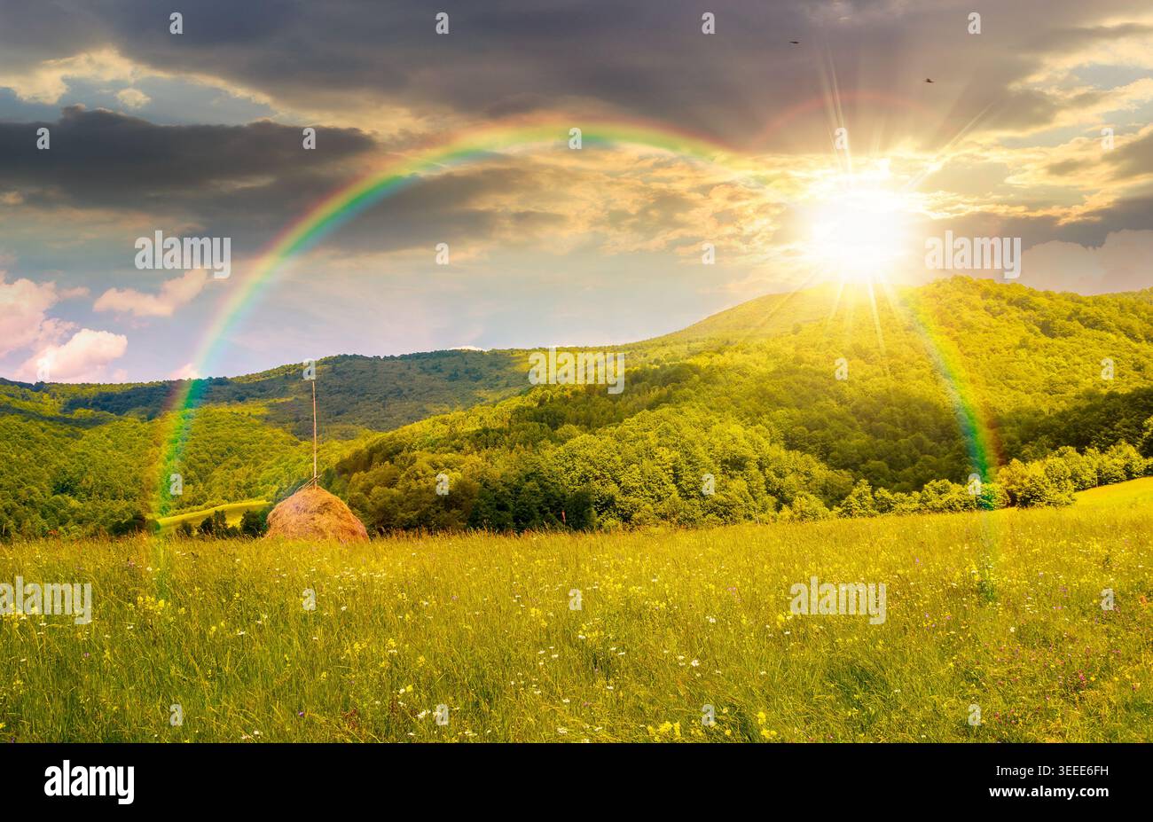 sunset over rural fields near pikui mountain in summertime. beautiful view of agricultural area. gorgeous mountain ridge with haystack on a grassy pas Stock Photo