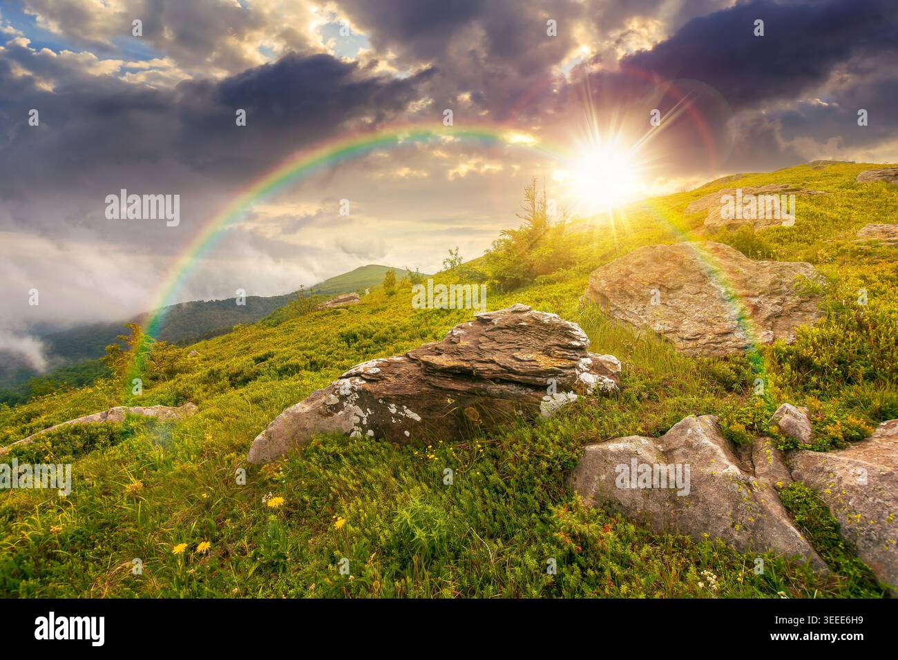 sunset over green landscape of mountain in summer. view of rock among grass on the hillside. travel background under a cloudy sky. mountain scenery wi Stock Photo