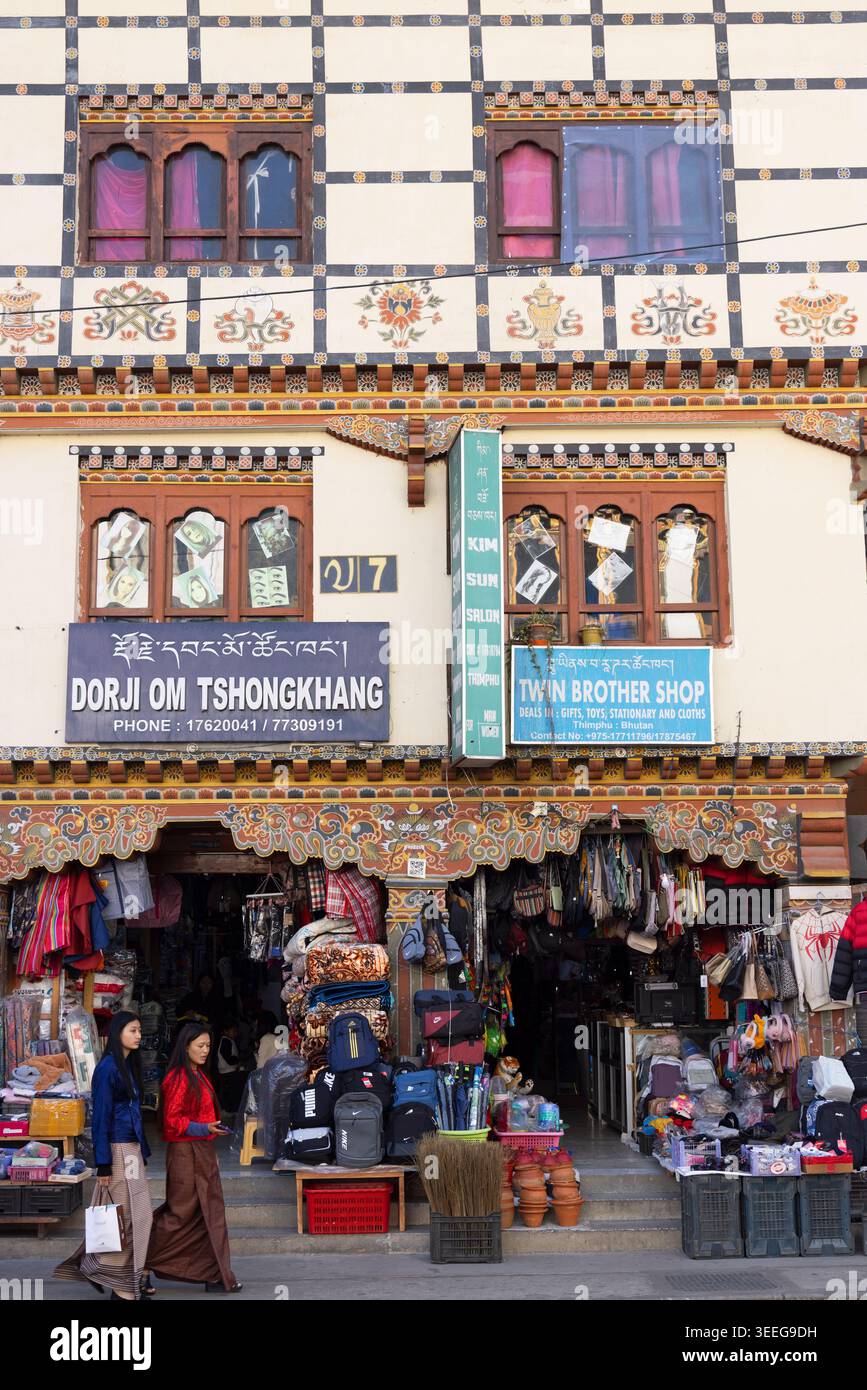 Women walking past stores, Thimphu, Bhutan Stock Photo