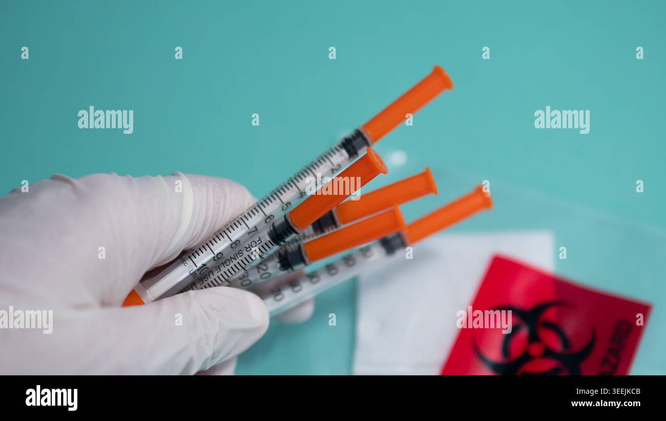 Gloved Hand Holding Orange Syringes with Biohazard Bag — Medical ...
