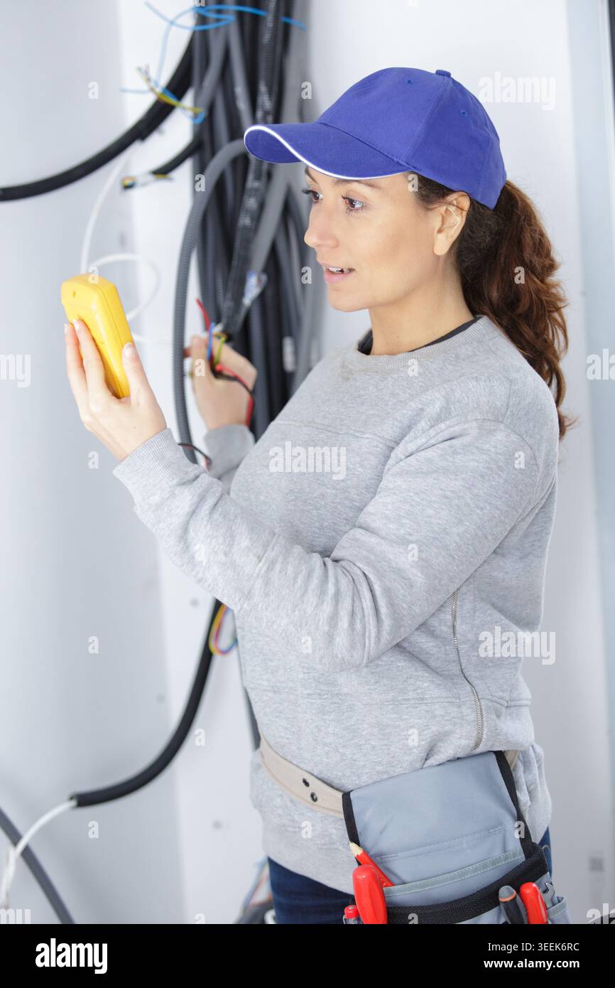 female electrician using a multimeter Stock Photo