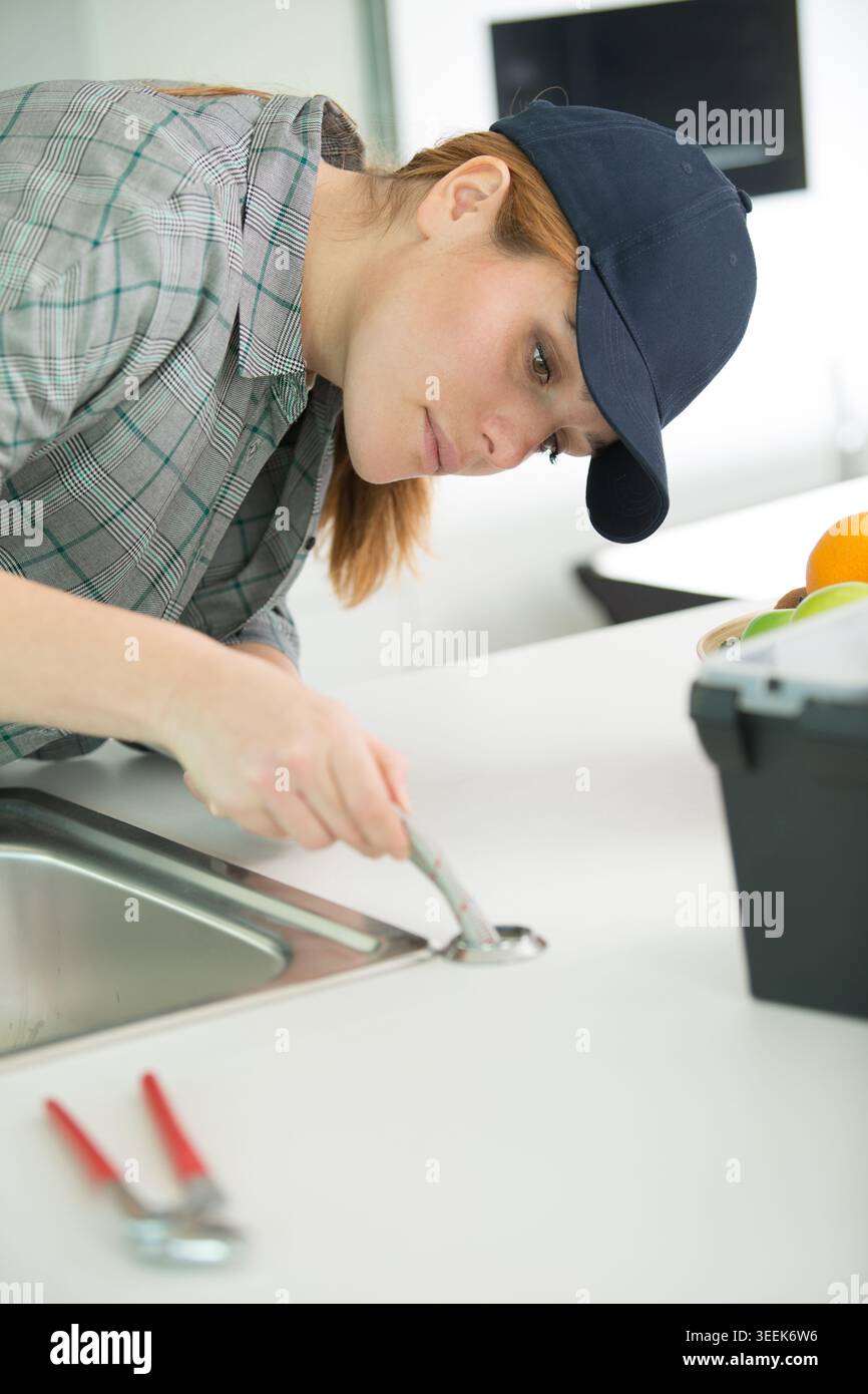 female plumber working on sink Stock Photo