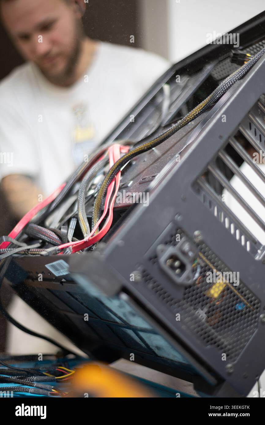 Technician works on computer hardware in a workshop in the afternoon Stock Photo