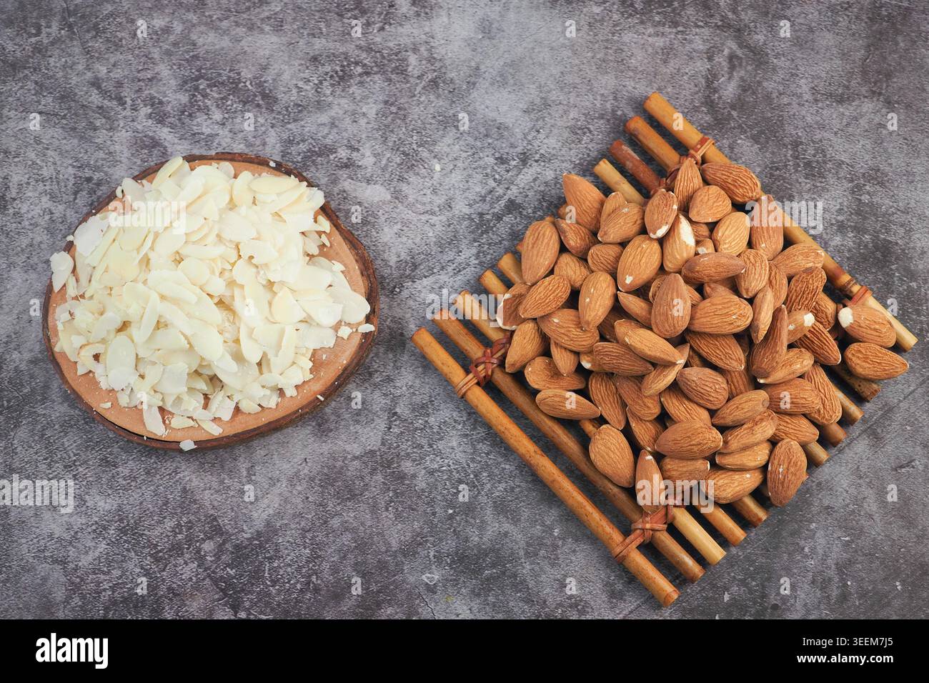 Almonds and sliced almonds on wooden surface Stock Photo