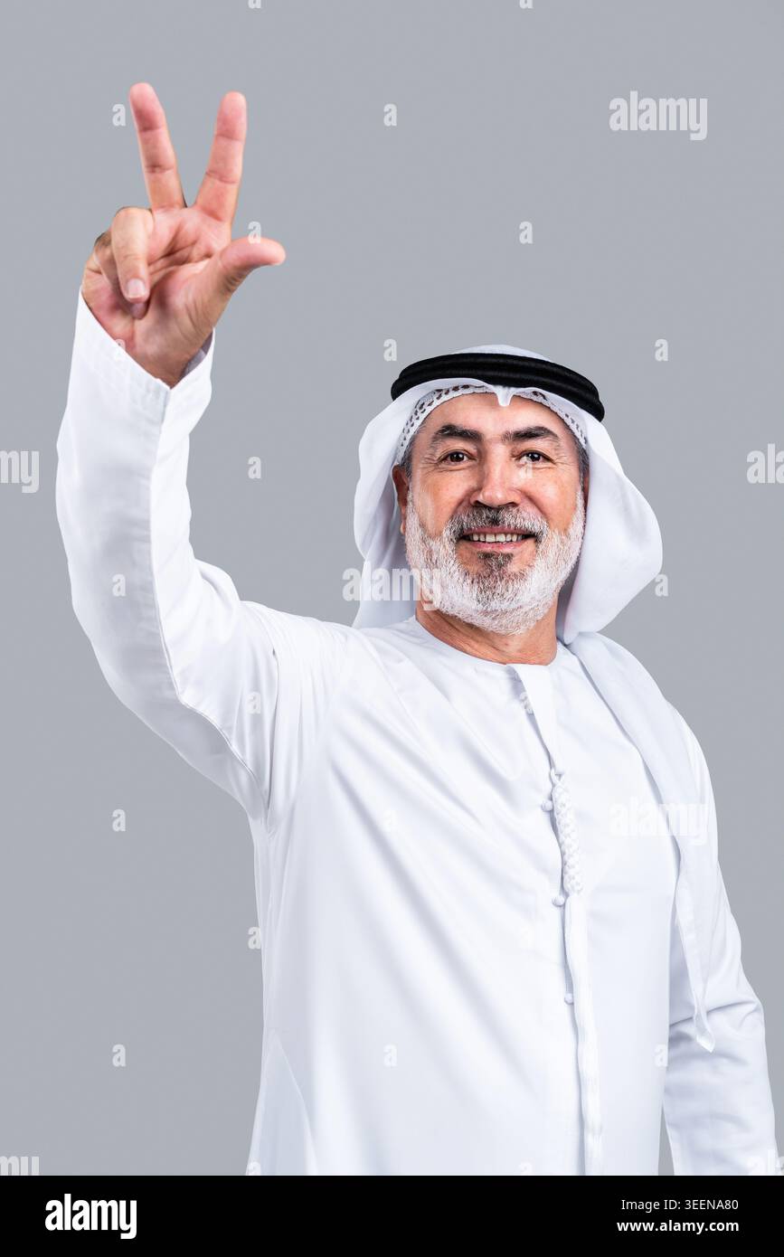 Senior emirati man smiling and raising his hand, showing the three ...