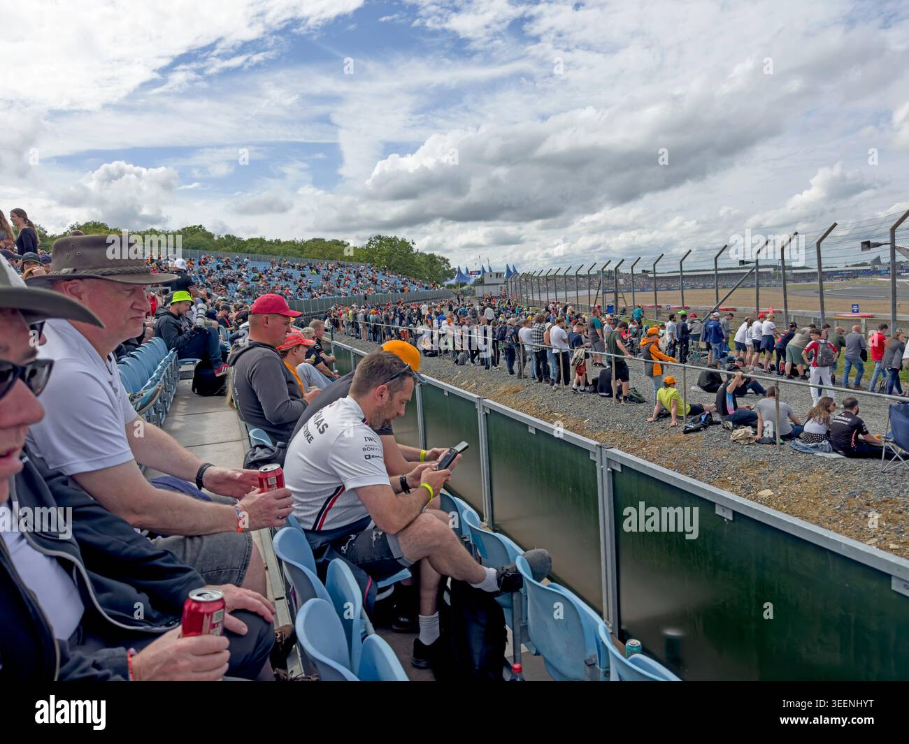Spectators watch British Grand Prix practice from a Silverstone grandstand during a Formula 1 race weekend. Stock Photo