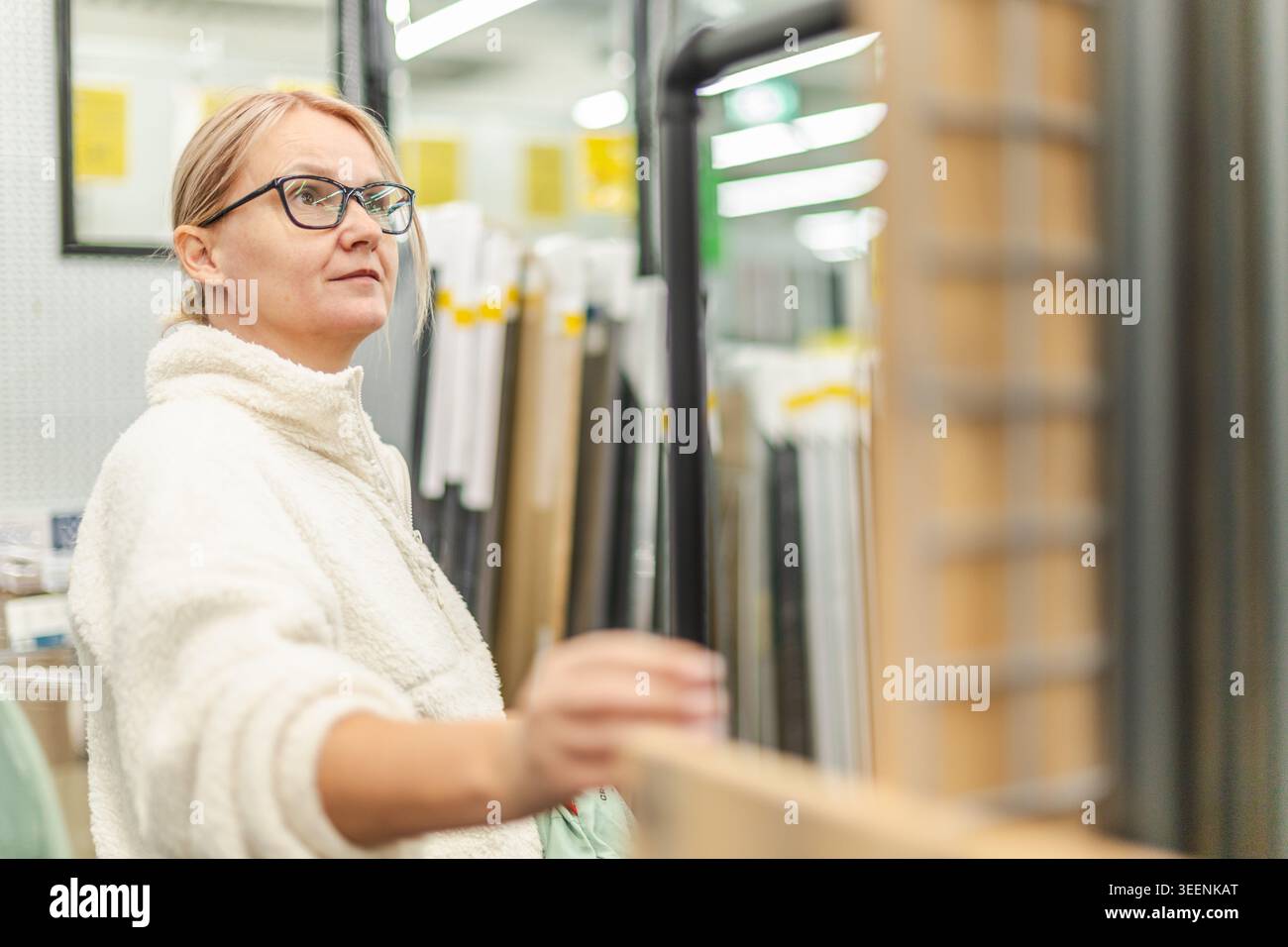 Woman browsing home renovation materials in hardware store interior Stock Photo