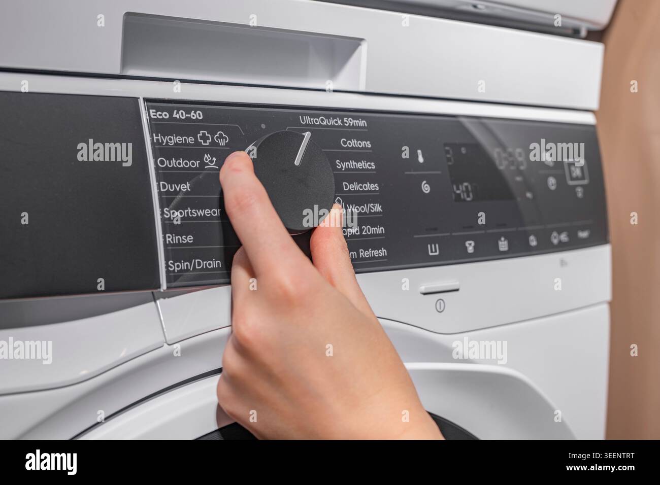 Setting and choosing laundry program on washing machine panel Stock Photo