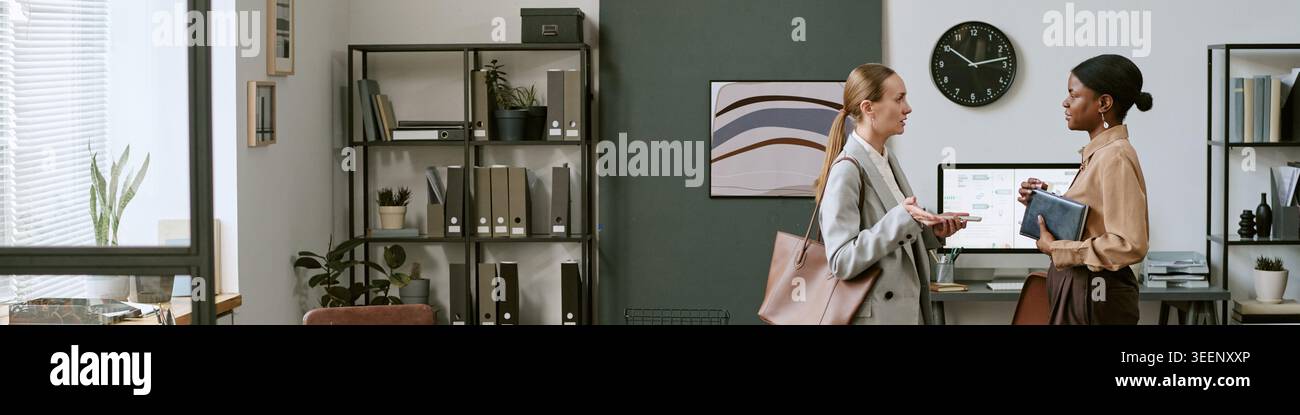 Businesswomen Discussing Project Planning in Modern Office Stock Photo