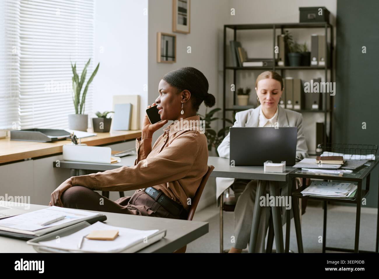 Black Woman Talking on Smartphone during Office Workday Stock Photo