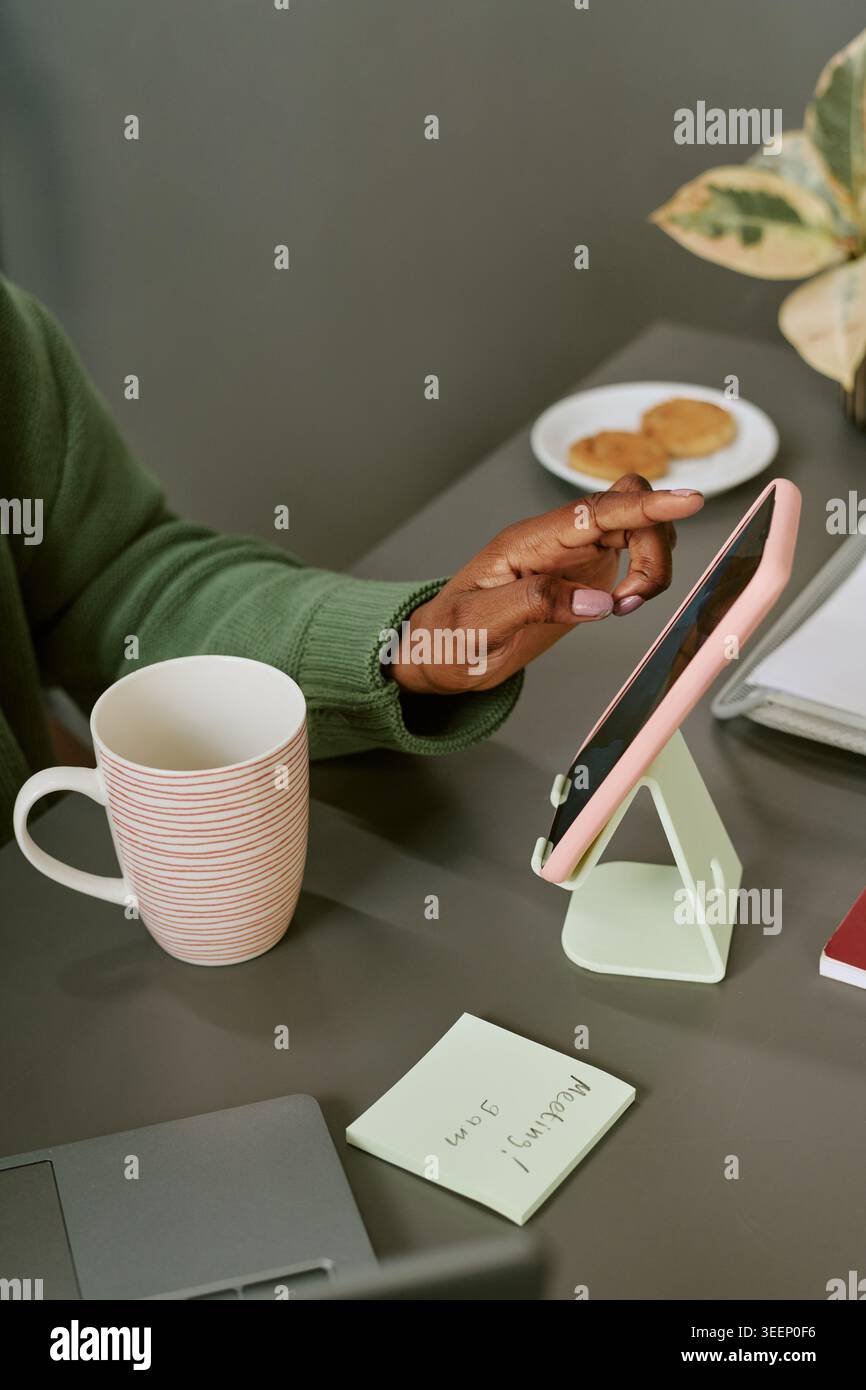 Black Woman Using Tablet for Remote Work and Digital Planning Stock Photo