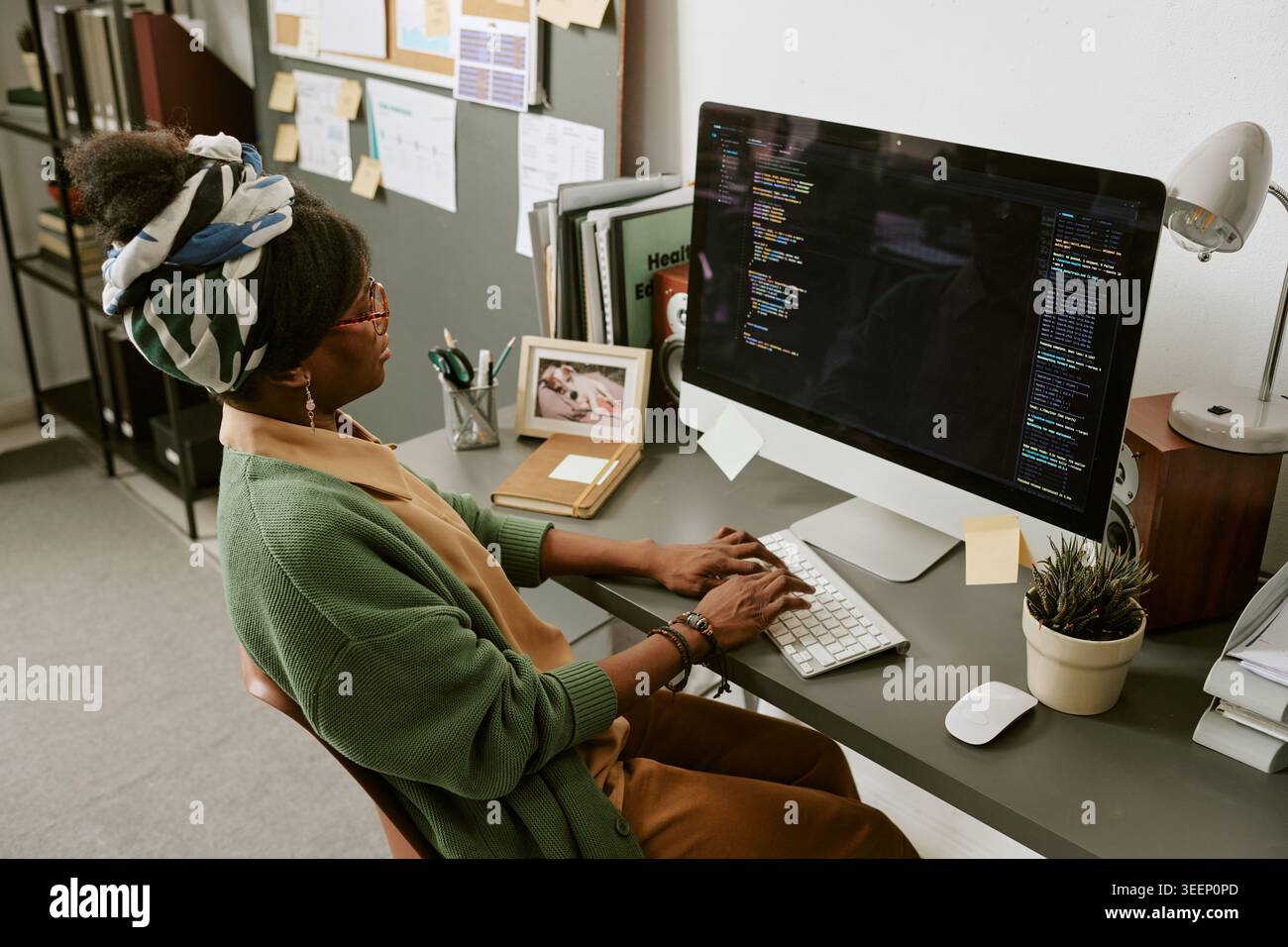 Black Woman Software Developer Coding at Desk in Home Office Stock Photo