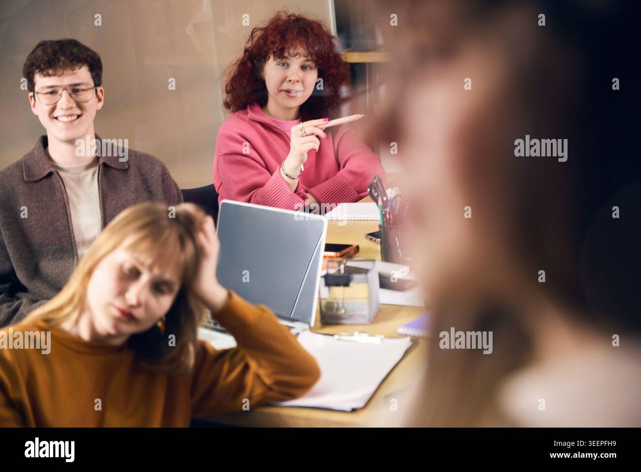 Creative office workers listening during team presentation in modern workspace. Stock Photo