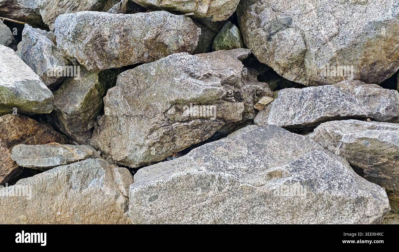 Textured rock pile presents variety of sizes, shapes. Neutral gray ...