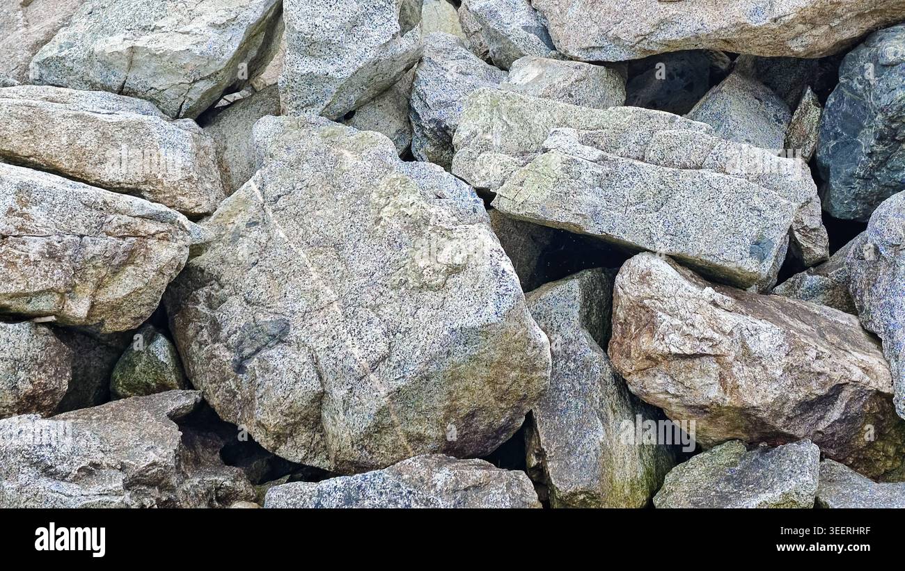 Highlights On Rocks Close-up depicts stacked granite rocks. Cool grey tones, rough textures ...