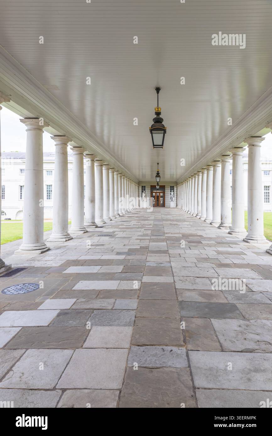Long empty colonnade with white pillars and stone floor Stock Photo