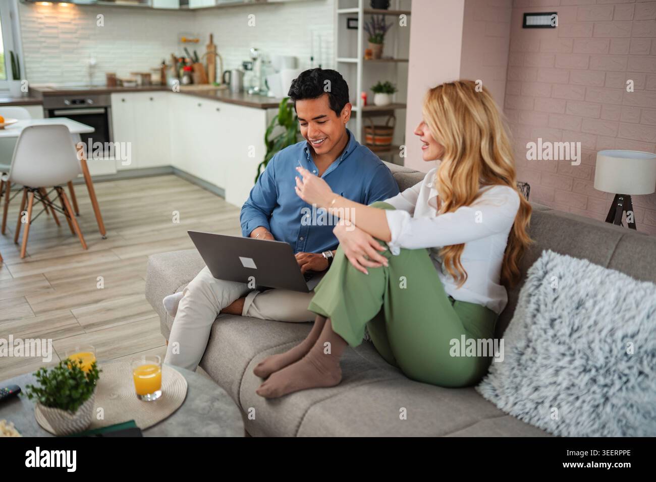 Couple relaxing on sofa using laptop at home Stock Photo