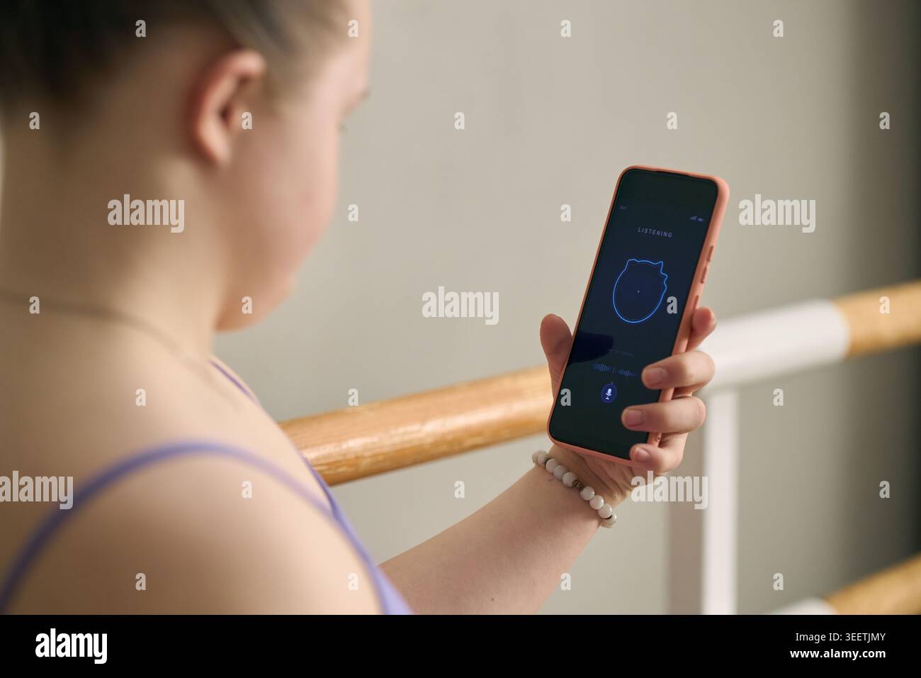 Girl with Down Syndrome Using Smartphone for Voice Assistant Stock Photo