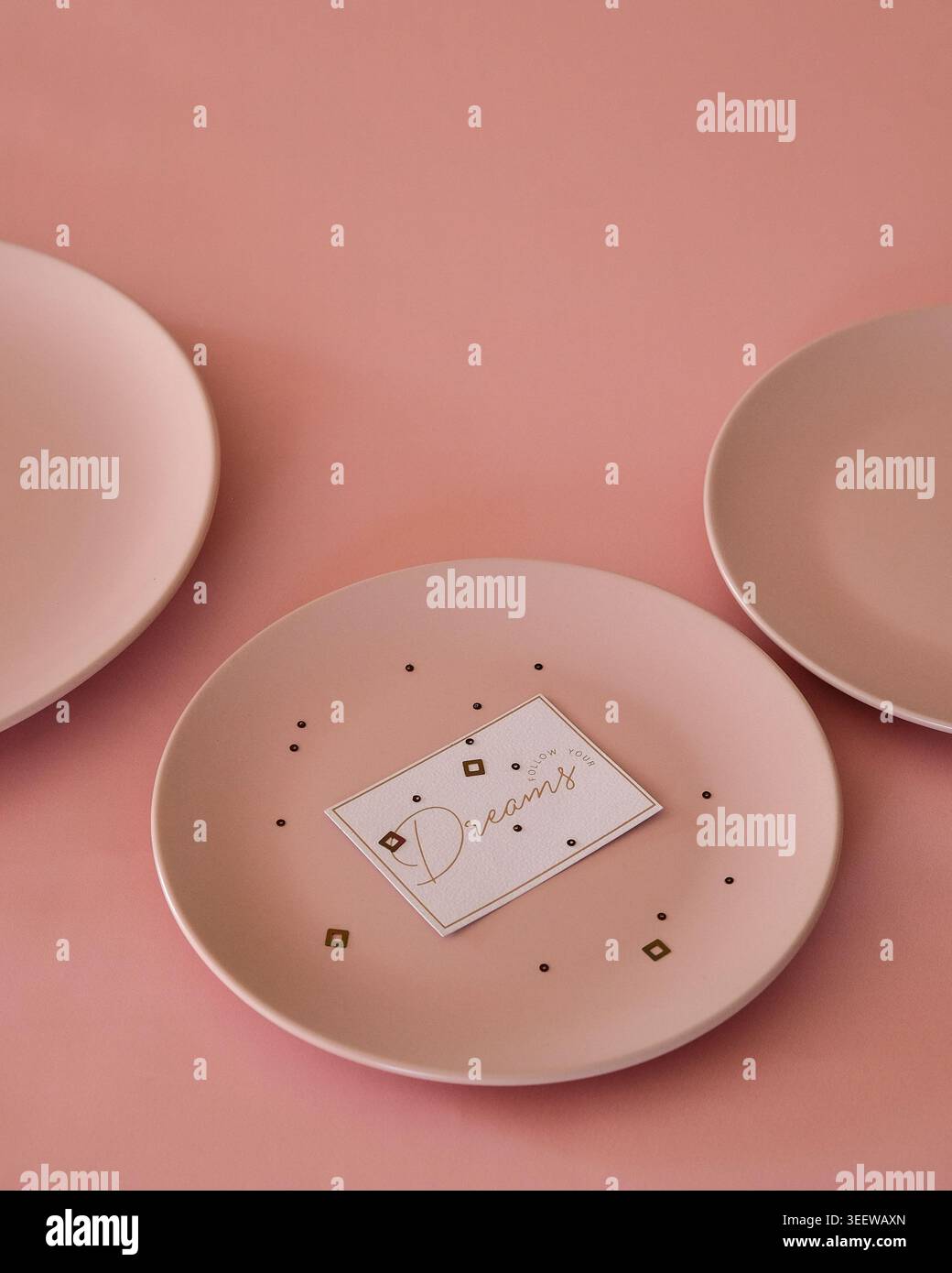 Minimalist pink setup showcasing ceramic plates on pastel background Stock Photo